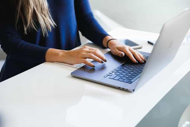Pessoa preenchendo um cadastro em um notebook