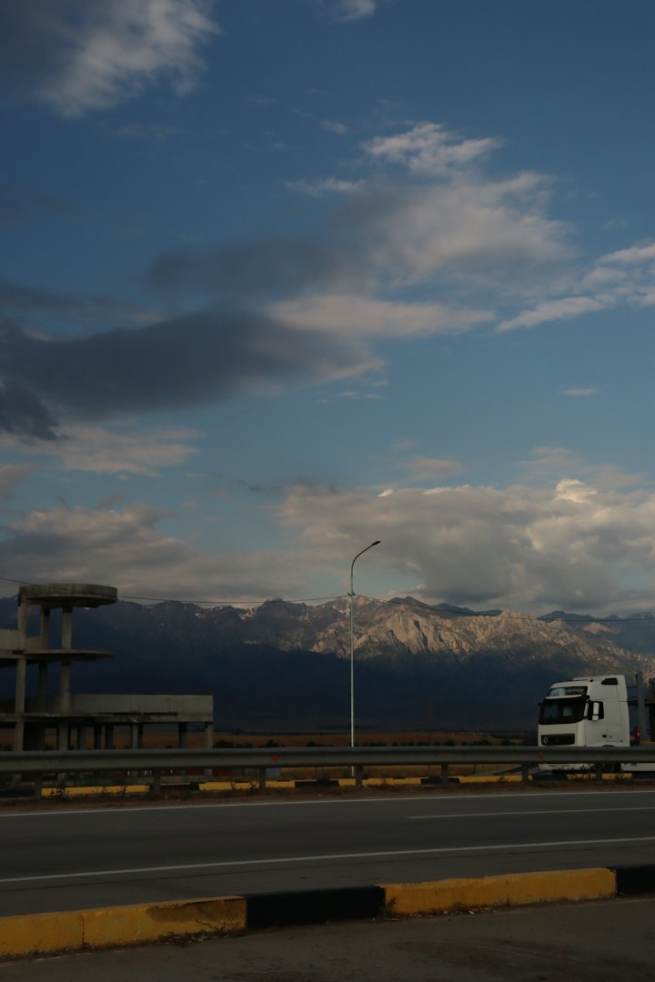 Caminhão em uma rodovia com montanhas ao fundo