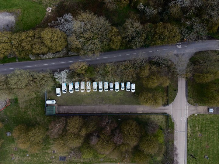 Vista aérea de vans brancas estacionadas ao longo de uma rua